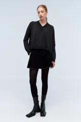 Sweater de tejido de punto color beige, con escote en V y calce holgado.