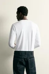 Camiseta slim fit de manga larga y cuello redondo, confeccionada en tejido de algodón elastizado de color marrón oscuro.