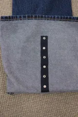 Jeans de denim azul oscuro con lavado vintage, tiro alto y corte acampanado.