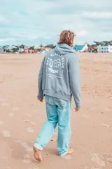 Hoodie gris con estampado en la espalda que incluye texto y dibujos.