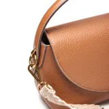 Bandolera de PU color habano con textura granulada, diseño de solapa curva y herrajes dorados. Incluye una correa ancha de tela estampada en tonos beige y marrón, y una correa larga regulable y desmontable.