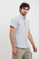 Camisa de manga corta a rayas verticales blancas y celestes, con cuello abotonado y bolsillo en el pecho.