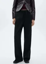 Pantalón de vestir negro de corte recto y pernera ancha, confeccionado en tejido fluido. Presenta cintura elástica con cordón ajustable y diseño de tiro medio.