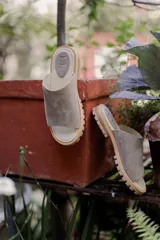 Sandalia tipo chinela de cuero marrón con textura granulada, plantilla de cuero y suela de madera con base de goma.