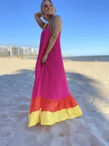 Vestido largo de tirantes color fucsia con volados en el ruedo en amarillo y naranja.