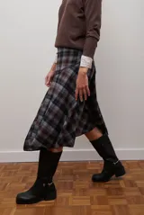 Falda midi de corte irregular con diseño a cuadros en tonos marrones, negros y beige. Presenta una silueta acampanada con caída fluida.