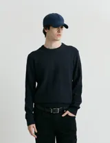 Sweater de punto con escote redondo, confeccionado en algodón con textura de punto fantasía en cuerpo y mangas, y terminaciones en punto canalé en cuello y puños.