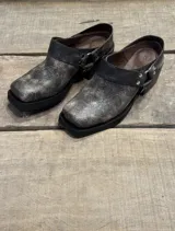 Zueco de cuero con efecto desgastado en tono visón, con punta cuadrada, suela de goma negra y detalle de hebilla metálica lateral.