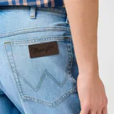 Short de jean celeste con corte recto, bolsillos delanteros y traseros, y etiqueta de cuero con el logo de Wrangler en la parte posterior.