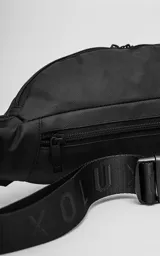 Riñonera negra confeccionada en cordura impermeable de alta resistencia. Presenta tres compartimentos principales con cierres metálicos, un bolsillo lateral adicional y una correa ajustable de alta densidad con broche de seguridad. Incluye una chapa metálica decorativa en el frente.
