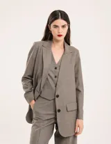 Chaleco de vestir gris oscuro con textura tipo tweed, escote en V y botones frontales. Corte levemente entallado y largo a la cintura.