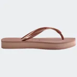 Ojotas Havaianas modelo Slim Flatform, color beige claro, con tiras finas metalizadas doradas y suela ligeramente elevada.