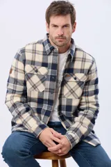 Campera leñadora de viyela a cuadros en tonos beige y azul oscuro, con interior forrado en corderito, cierre frontal con botones y dos bolsillos con solapa en el pecho.