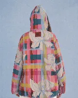 Campera impermeable con capucha y cordón ajustable, con diseño estampado a cuadros multicolor y hojas grandes. Cuenta con cierre frontal de botones y bolsillos laterales.