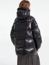 Campera puffer de corte holgado con acabado brillante, cierre frontal y capucha integrada.