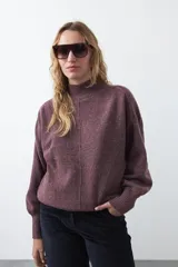 Polera de punto color bordó melange, con cuello alto, mangas largas abullonadas y puños acanalados.