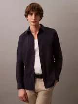 Camisa de manga larga Calvin Klein con corte slim, cuello clásico estructurado y cierre frontal con botones a tono. Presenta un diseño minimalista con monograma bordado en el pecho.