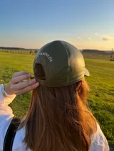 Set de tres gorras de cuero con viseras de diferentes colores: marrón oscuro, verde oliva y rojo ladrillo. La gorra superior tiene un bordado sutil en hilo claro.
