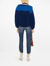 Buzo polar deportivo azul marino y celeste con cuello polo y cierre de cremallera parcial.