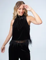 Conjunto de dos piezas compuesto por una musculosa de cuello alto con detalle de plumas en el ruedo y un pantalón de corte recto, ambos confeccionados en terciopelo negro.