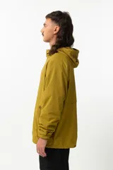 Campera de nylon color mostaza, estilo 'gorpcore', con forro de jersey de algodón y corte confortable. Presenta cierre frontal, capucha y bolsillos laterales. Estampado en el pecho con el logo de la marca y la frase "Release the hounds".