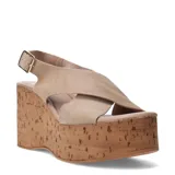 Sandalias de plataforma alta tipo cuña con acabado de corcho. Presentan tiras cruzadas en el empeine confeccionadas en gamuza color beige y una pulsera ajustable con hebilla metálica en el tobillo.