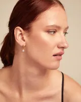 Aros colgantes dorados con dije de cristal blanco.