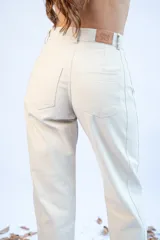 Pantalón baggy color beige con bolsillos laterales y traseros.