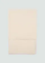 Fular rectangular color crema, confeccionado en tejido mezcla de lino y viscosa, con terminaciones deshilachadas.