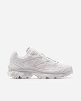Championes Salomon modelo XT-6, color blanco con detalles sutiles en gris y acentos multicolor en el sistema de cordones. Diseñados para trail running, cuentan con una estructura resistente, suela con agarre técnico y sistema de ajuste rápido.