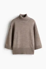 Buzo de punto fino suave color marrón, con mangas tres cuartos, cuello alto acanalado, hombros caídos y remates acanalados en puños y bajo.
