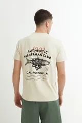 Remera color beige con estampado circular en el pecho con texto en negro.