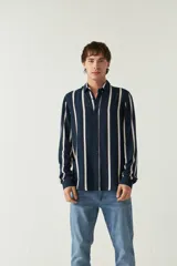 Camisa de mangas largas con estampado a rayas verticales en tonos verde oliva, blanco y azul. Corte regular y logo bordado en el pecho. Confeccionada en viscosa.