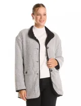 Cardigan de tejido de punto con diseño de espiga en color beige, totalmente forrado en corderito sintético blanco. Presenta cuello solapa, cierre frontal con botones, bolsillos tipo parche con solapa y terminaciones con vivos en contraste.