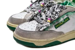 Zapatillas casual Arizona Love con base color beige, puntera blanca y detalles de tela estampada con motivos de leopardo y flores. Cordones gruesos rojos con cuentas de colores.