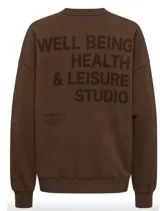Buzo oversize de mujer color celeste, con cuello redondo, mangas largas y hombros caídos. Cuenta con un pequeño estampado frontal con texto en el pecho.