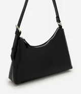 Cartera tipo baguette de tamaño pequeño, confeccionada en poliuretano color negro. Presenta un diseño minimalista con cierre de cremallera metálica superior, herrajes en níquel y una correa de hombro ajustable.