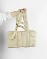 Bolso tipo tote color beige con diseño acolchado y doble asa de hombro.
