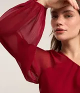 Blusa de chiffon color rojo, con hombro único, manga larga abullonada y puño elástico.