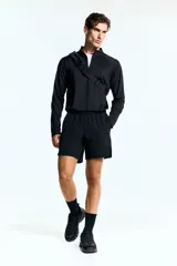 Short deportivo negro a media pierna confeccionado en tejido funcional con tecnología DryMove™, elástico en la cintura con cordón de ajuste oculto, bolsillos al bies, diseño reflectante en la parte posterior y aberturas laterales cortas en el bajo.