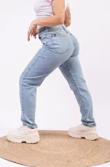 Jean estilo mom fit color celeste vintage, con tiro alto y diseño relajado que se afina hacia los tobillos.