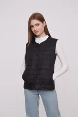 Chaleco acolchado color verde militar con cierre de botones a presión.