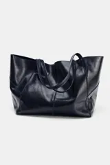 Bolso formato maxi shopper de piel con acabado brillante, detalle de pespuntes a tono y asas de hombro. Incluye una cartera extraíble con cierre y logo de la marca grabado.