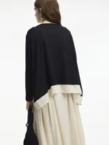 Sweater beige de viscosa y lino, de corte amplio con mangas largas ajustadas y detalle de superposición en el bajo.