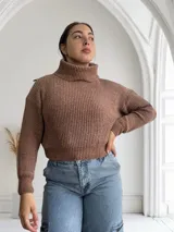 Sweater marrón de punto con cuello alto y mangas largas.