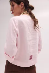 Blusa de lino color marrón con cuello mao, escote en V y mangas largas.