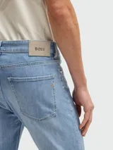 Jeans de corte slim fit en color azul claro con efecto lavado. Presenta cierre de botón y cremallera, cinco bolsillos clásicos y costuras reforzadas.