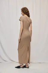 Vestido largo negro de calce al cuerpo, con cuello redondo, mangas cortas y detalle drapeado en el lateral de la cintura con una hebilla metálica dorada.