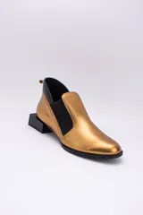 Zapato de cuero color dorado con elásticos laterales negros, taco cuadrado negro y tirador trasero.