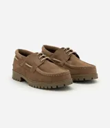 Zapato estilo náutico para hombre, confeccionado en cuero gamuza color marrón. Presenta diseño liso con puntera redondeada, costura aparente en la capellada, cordones bicolor y suela tractorada engomada.